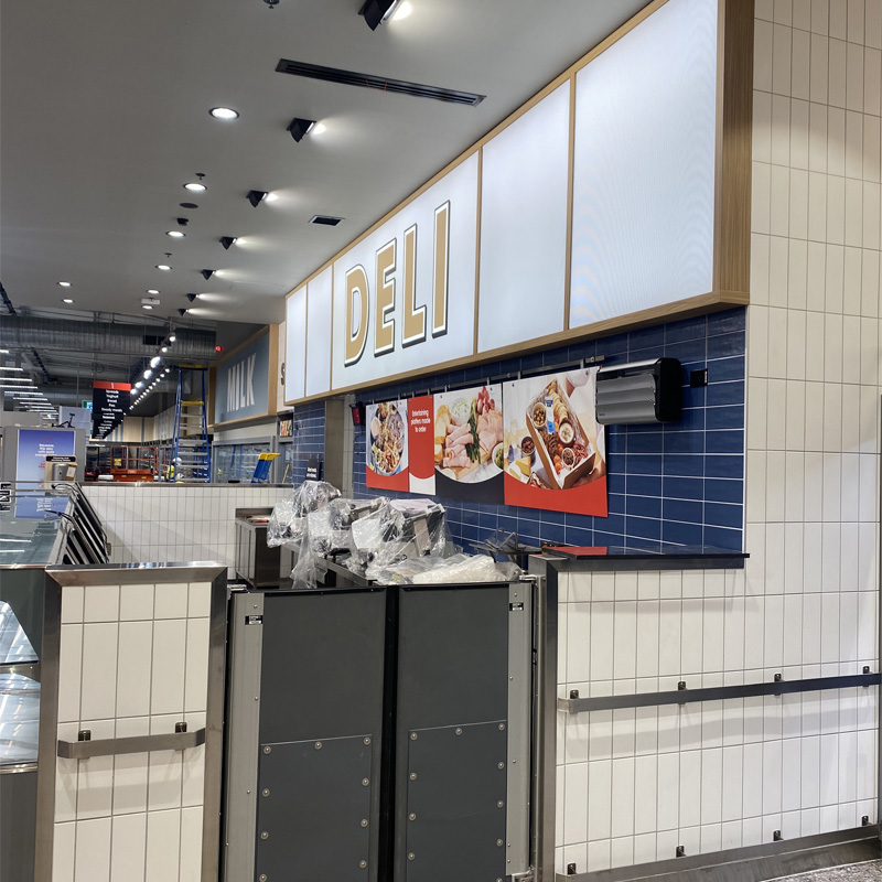 Blue wall tiles and a white tiled counter base at a supermarket deli