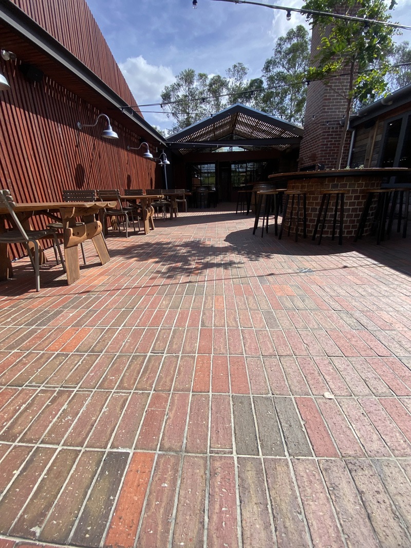 Red brick-look paving in an outdoor beer garden with tables