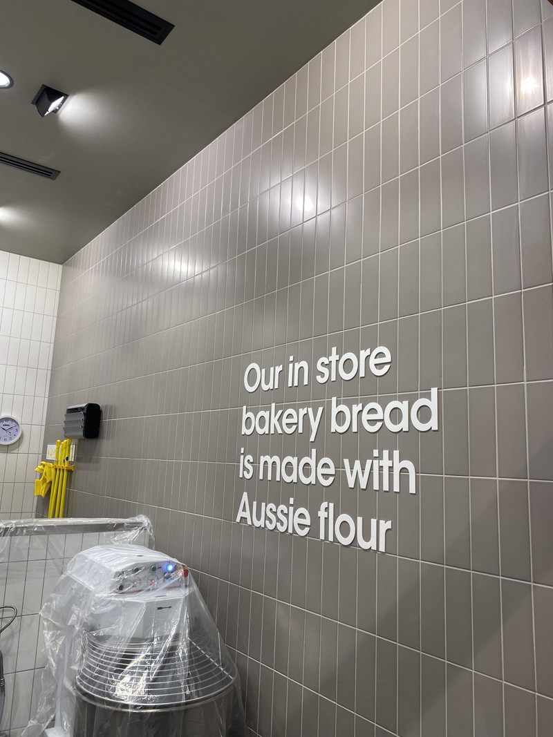 Grey wall tiles with the words "Our in store bakery bread is made with Aussie flour"