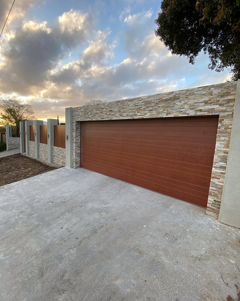 Stacked stone tiles on a front fence and garage wall