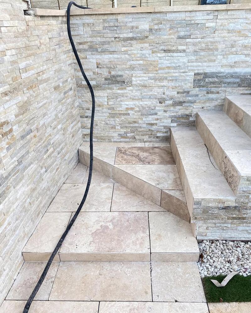 Stacked stone wall tiles beside stone-tiled outdoor steps
