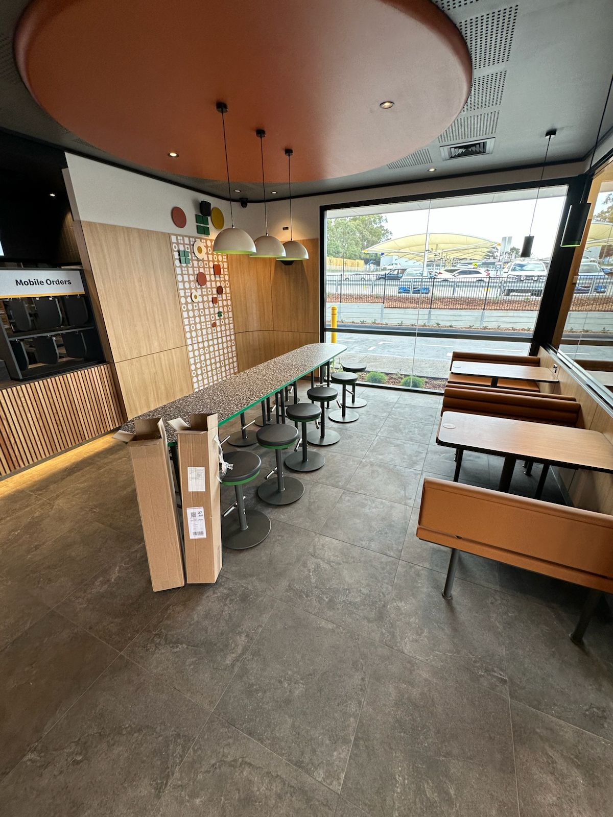 Grey floor tiles in a restaurant dining area with a window bench and stools