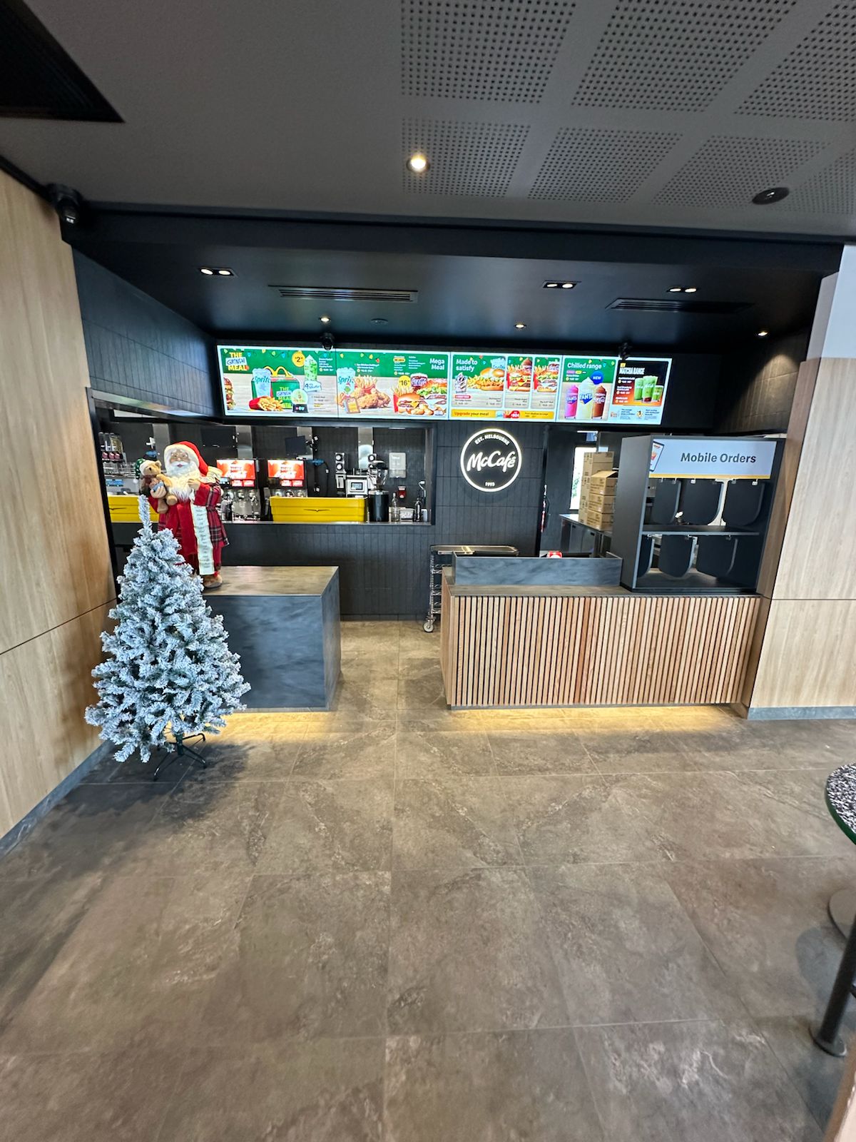 Grey floor tiles in front of a McCafé counter with a Christmas tree