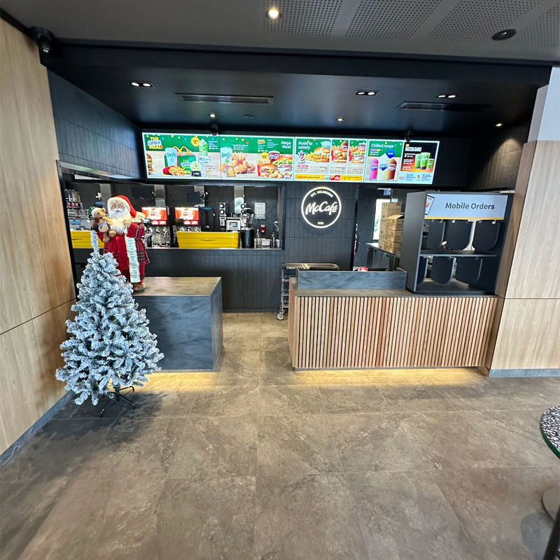 Grey floor tiles in front of a McCafé counter with a Christmas tree